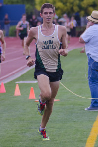 Athlete prepares for pole vault on a track with others watching.