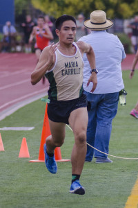 Athlete prepares for pole vault on a track with others watching.