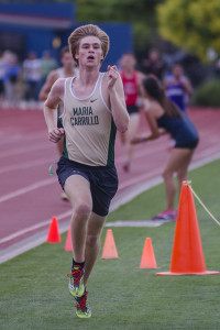 Athlete prepares for pole vault on a track with others watching.