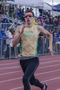 Athlete prepares for pole vault on a track with others watching.