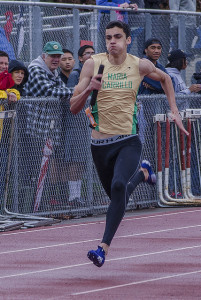 Athlete prepares for pole vault on a track with others watching.