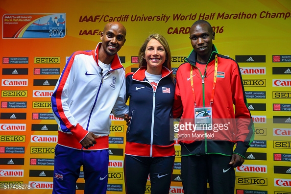 Athlete prepares for pole vault on a track with others watching.