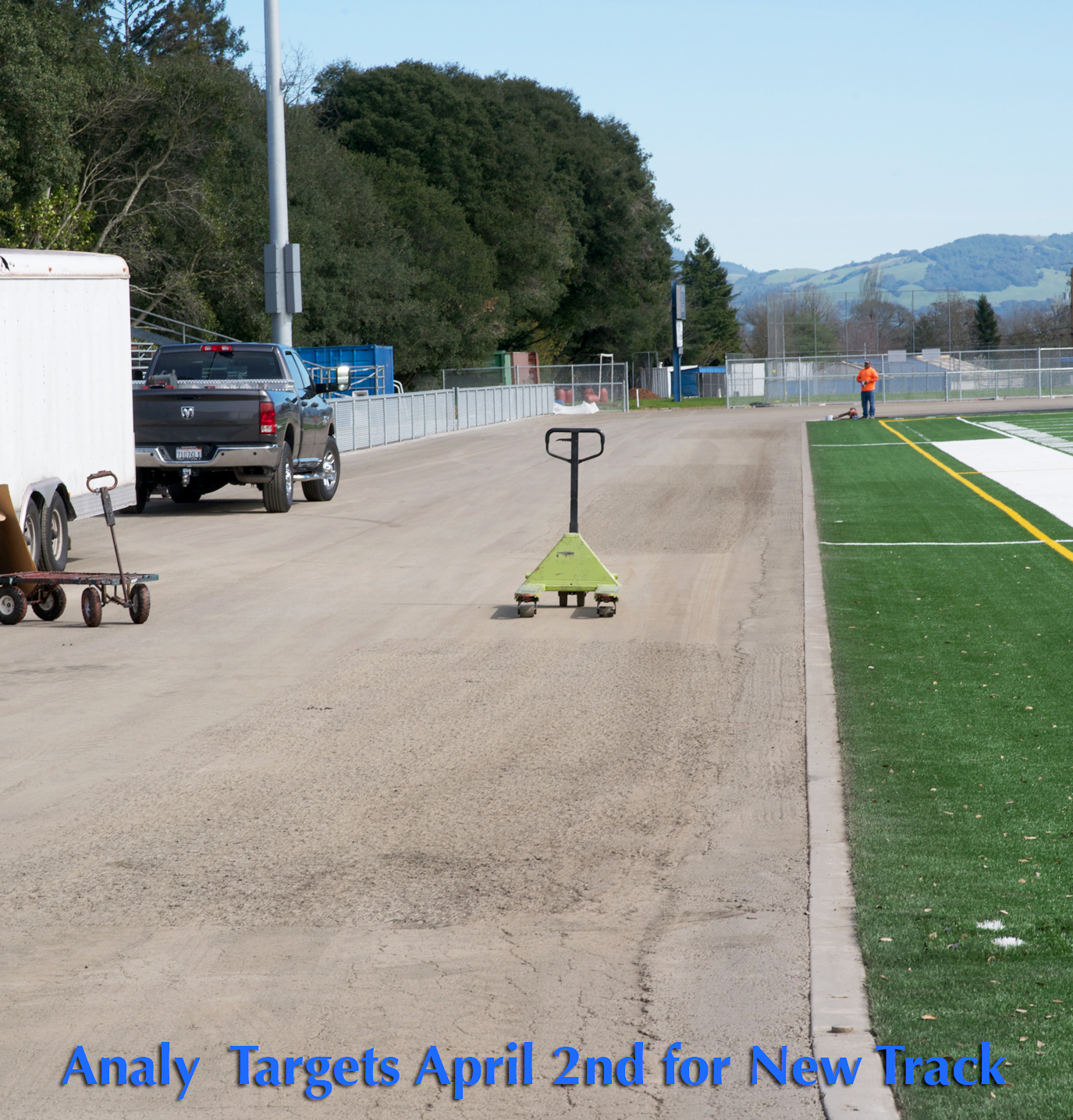 Athlete prepares for pole vault on a track with others watching.