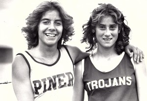 Athlete prepares for pole vault on a track with others watching.