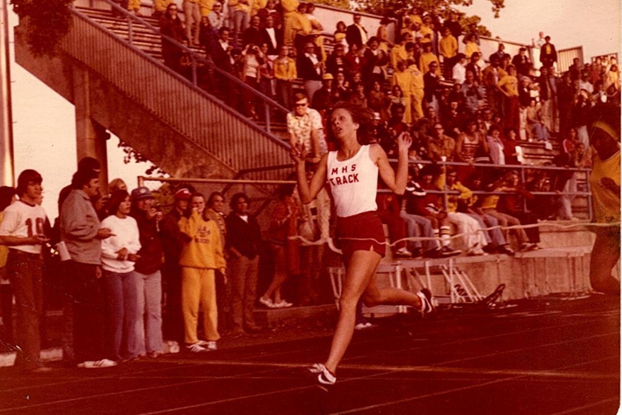 Athlete prepares for pole vault on a track with others watching.