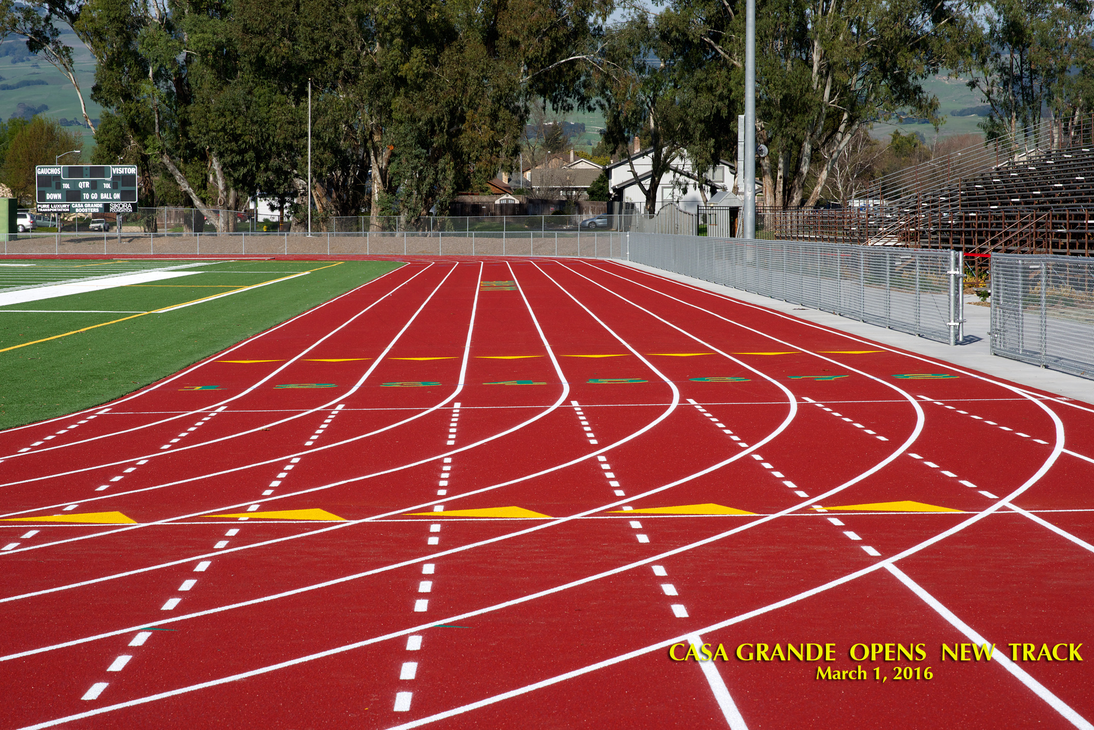Athlete prepares for pole vault on a track with others watching.