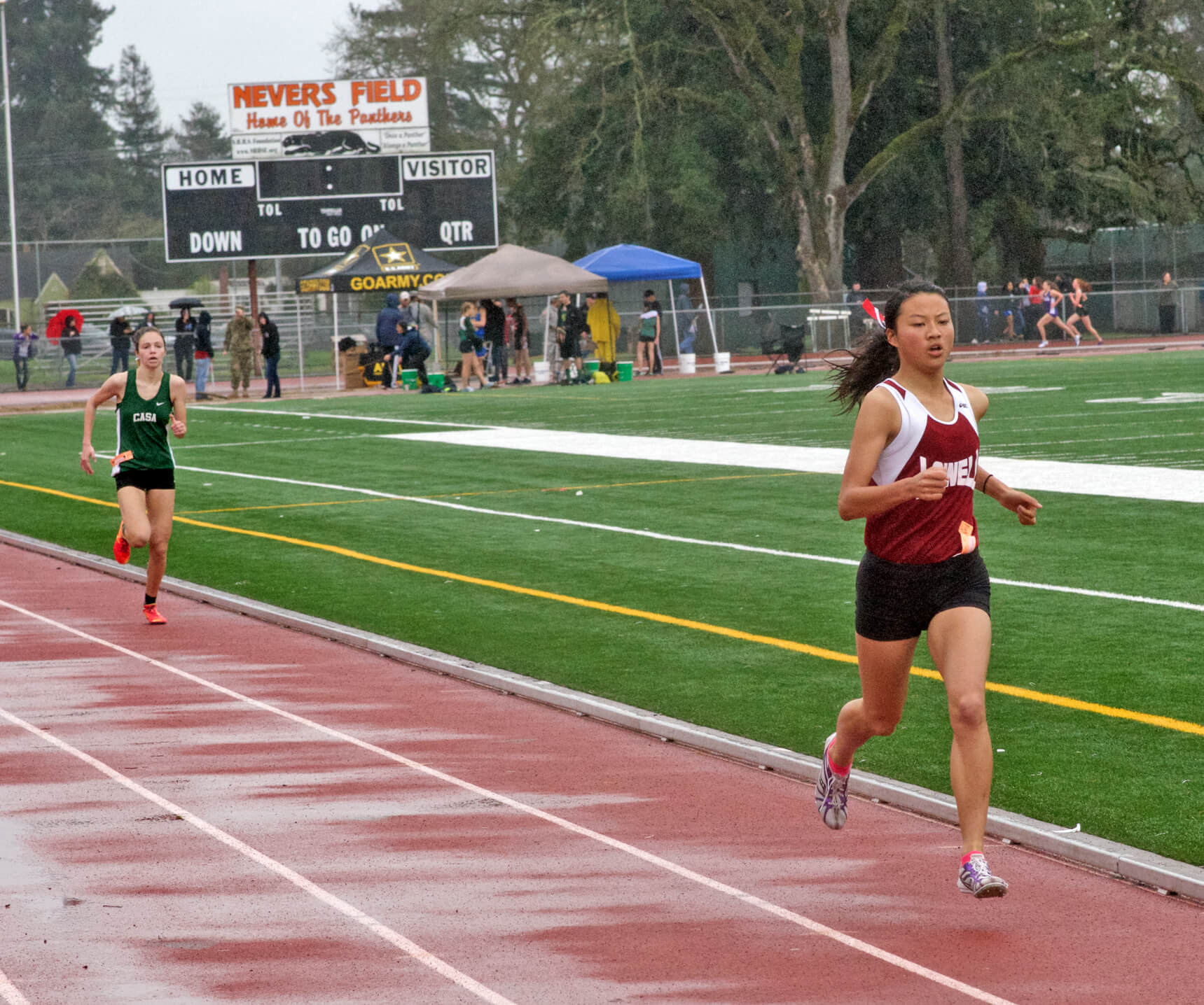Athlete prepares for pole vault on a track with others watching.