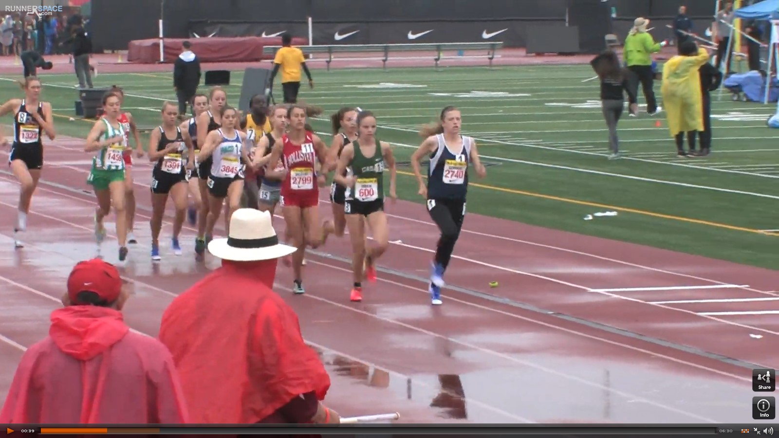 Athlete prepares for pole vault on a track with others watching.