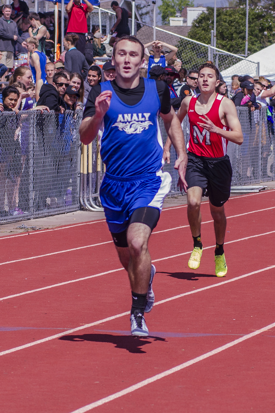 Athlete prepares for pole vault on a track with others watching.