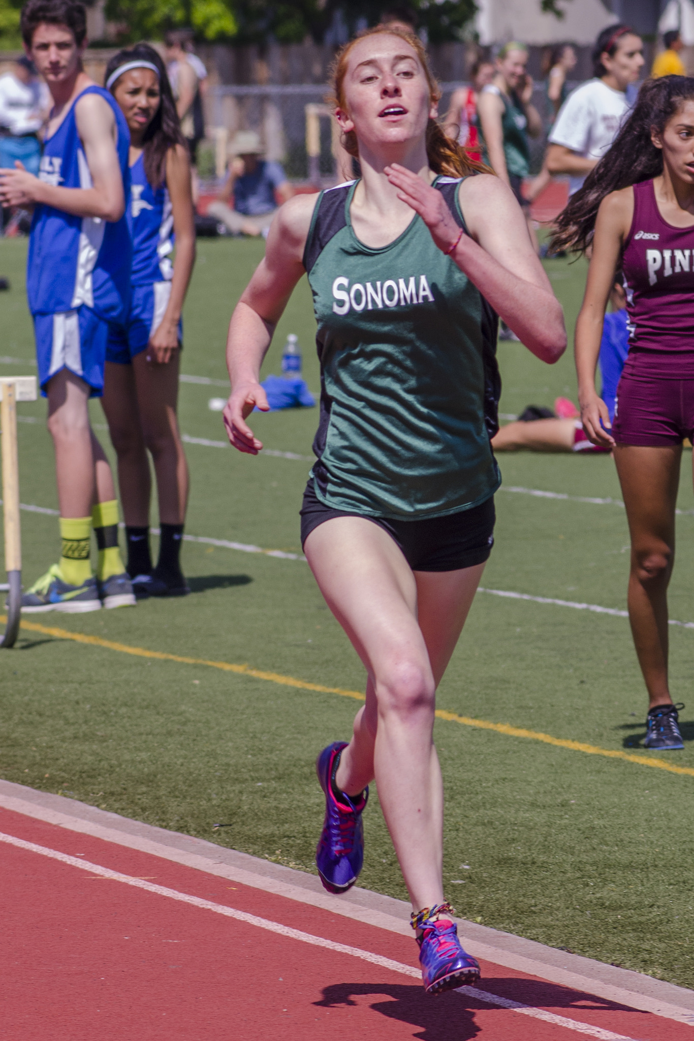 Athlete prepares for pole vault on a track with others watching.