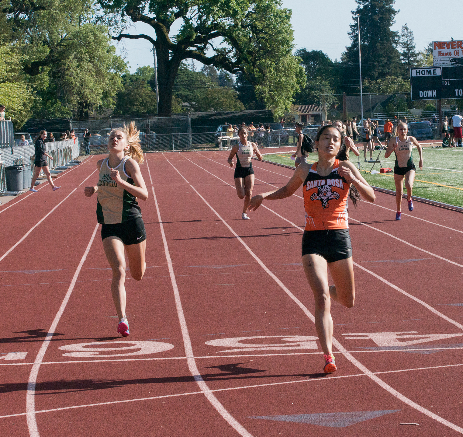 Athlete prepares for pole vault on a track with others watching.