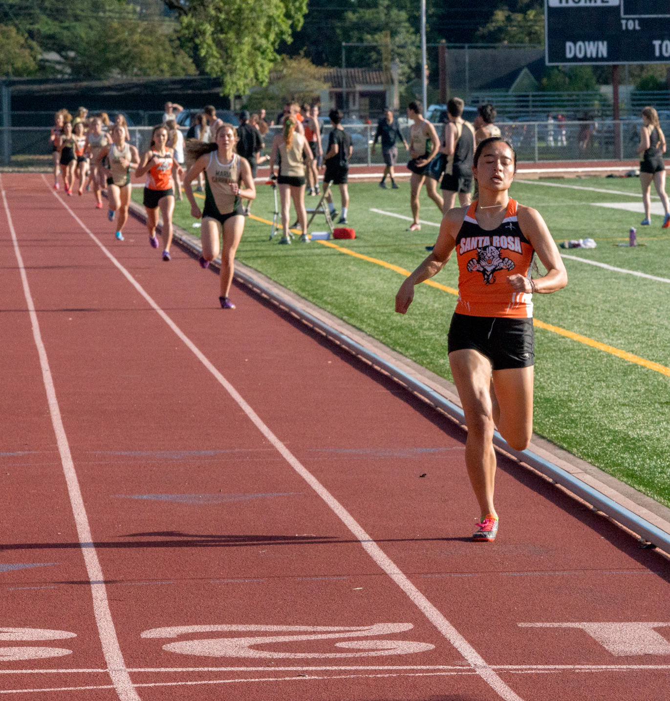 Athlete prepares for pole vault on a track with others watching.