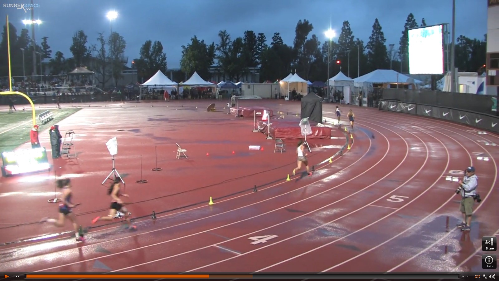 Athlete prepares for pole vault on a track with others watching.