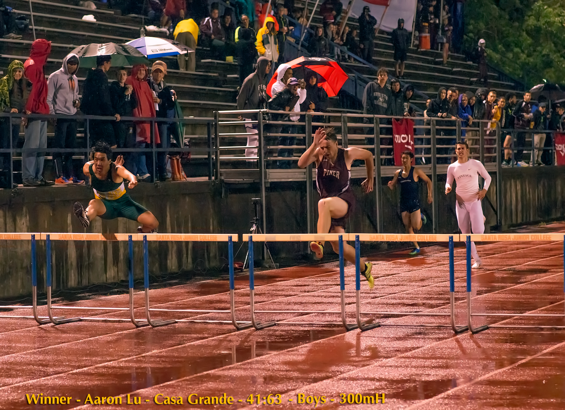 Athlete prepares for pole vault on a track with others watching.