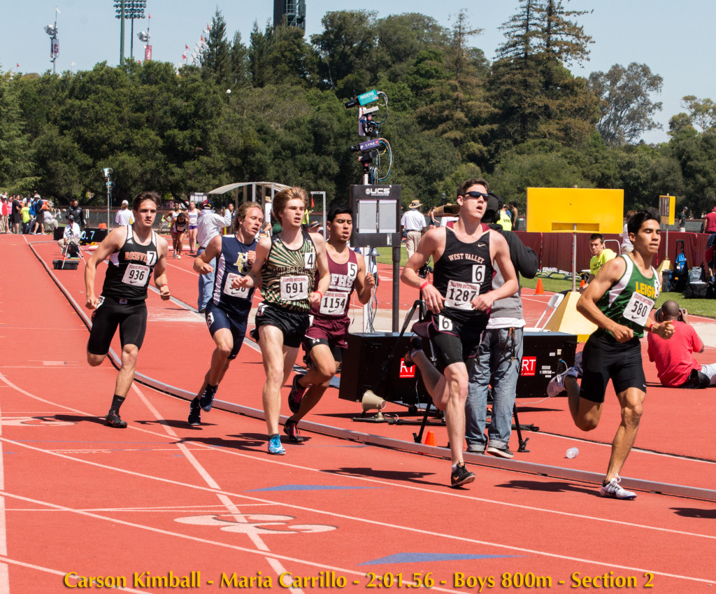Athlete prepares for pole vault on a track with others watching.