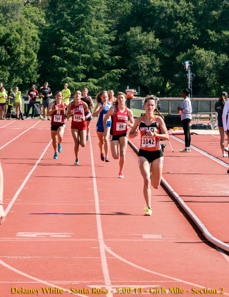 Athlete prepares for pole vault on a track with others watching.