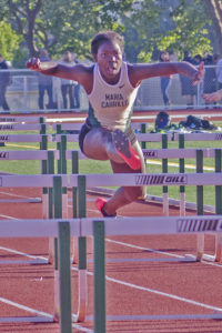 Athlete prepares for pole vault on a track with others watching.