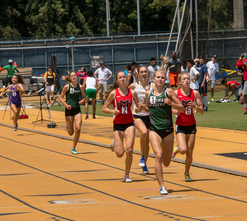 Athlete prepares for pole vault on a track with others watching.