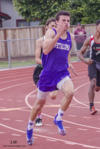Athlete prepares for pole vault on a track with others watching.