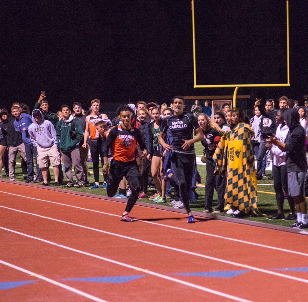 Athlete prepares for pole vault on a track with others watching.