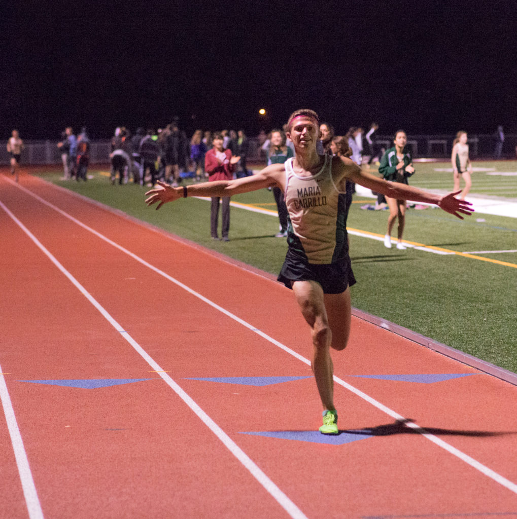 Athlete prepares for pole vault on a track with others watching.