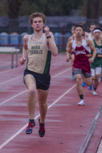 Athlete prepares for pole vault on a track with others watching.