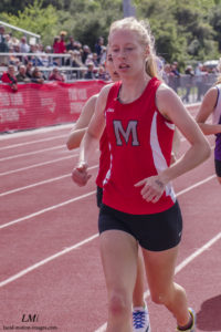 Athlete prepares for pole vault on a track with others watching.