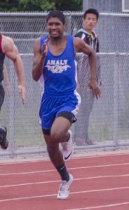 Athlete prepares for pole vault on a track with others watching.