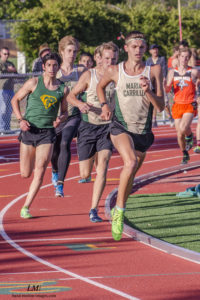 Athlete prepares for pole vault on a track with others watching.