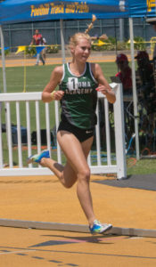 Athlete prepares for pole vault on a track with others watching.