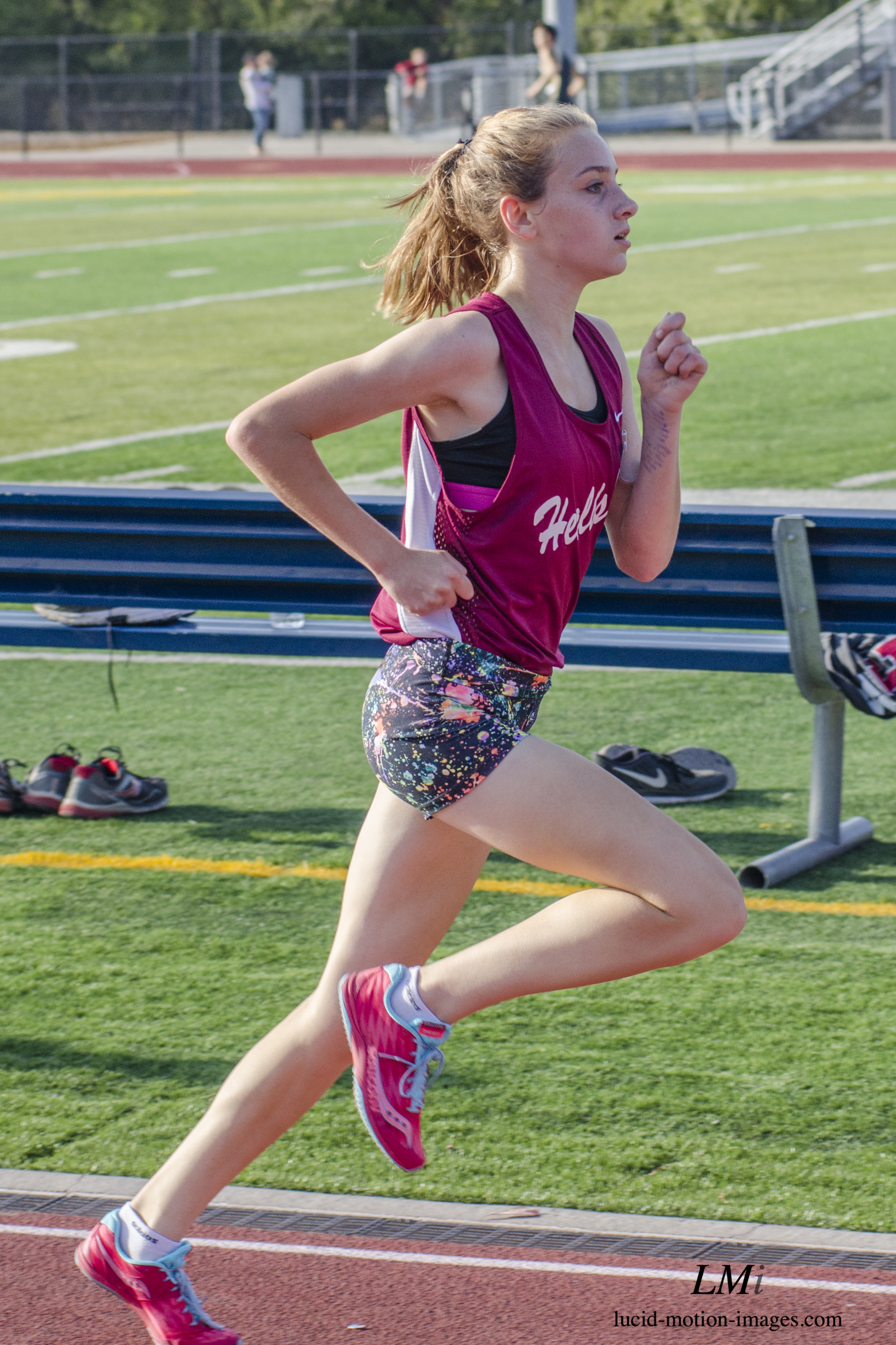 Athlete prepares for pole vault on a track with others watching.