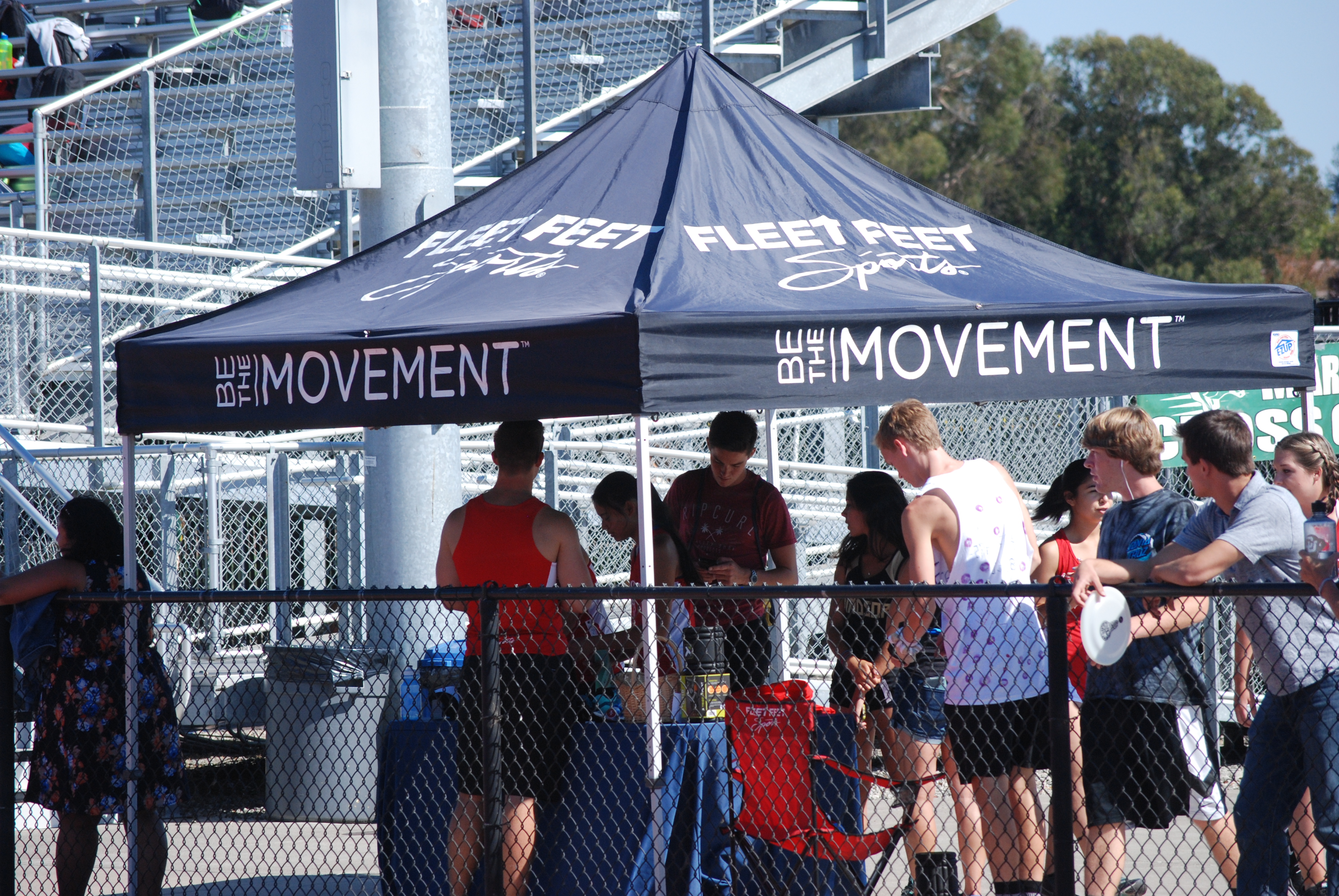 Athlete prepares for pole vault on a track with others watching.