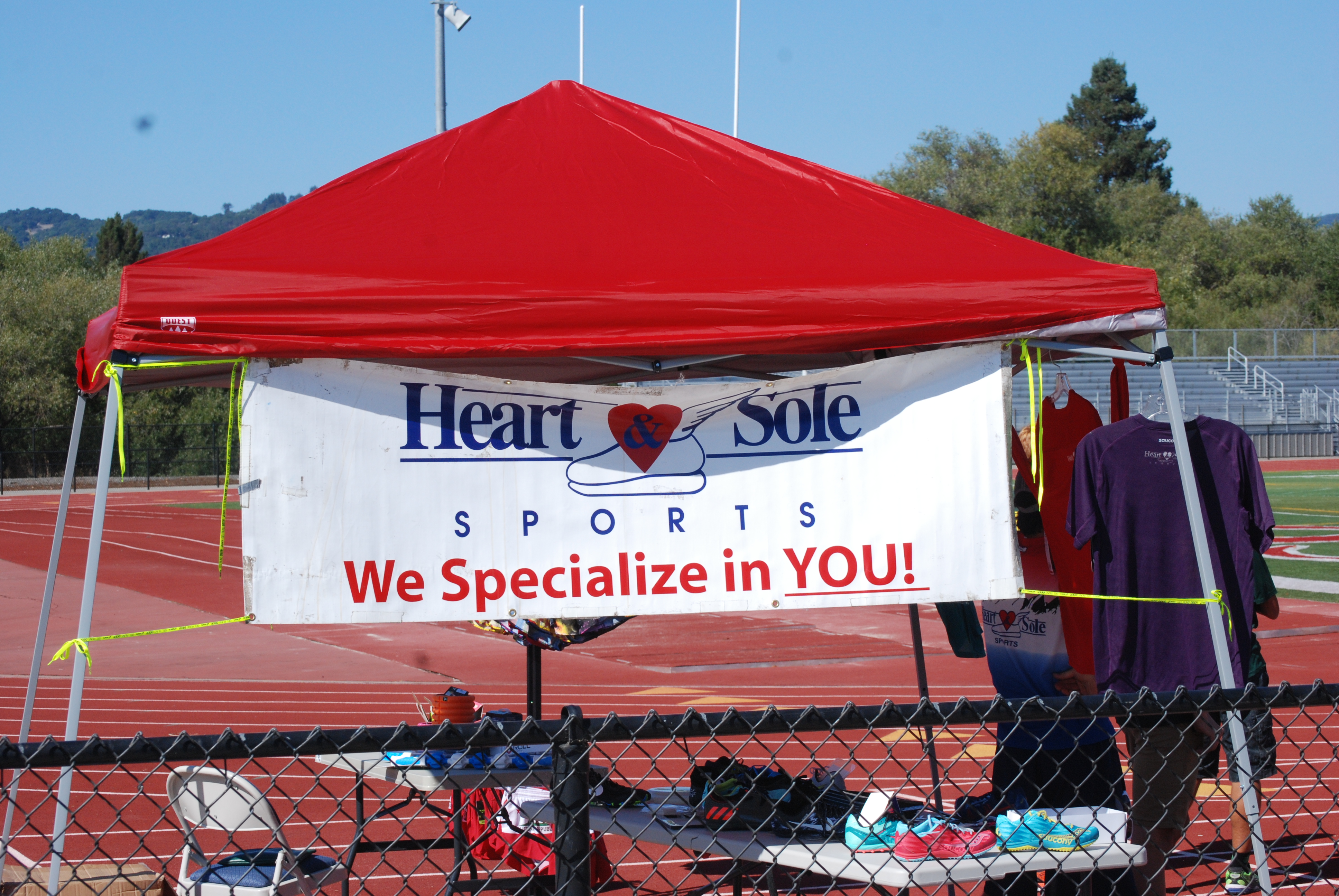 Athlete prepares for pole vault on a track with others watching.