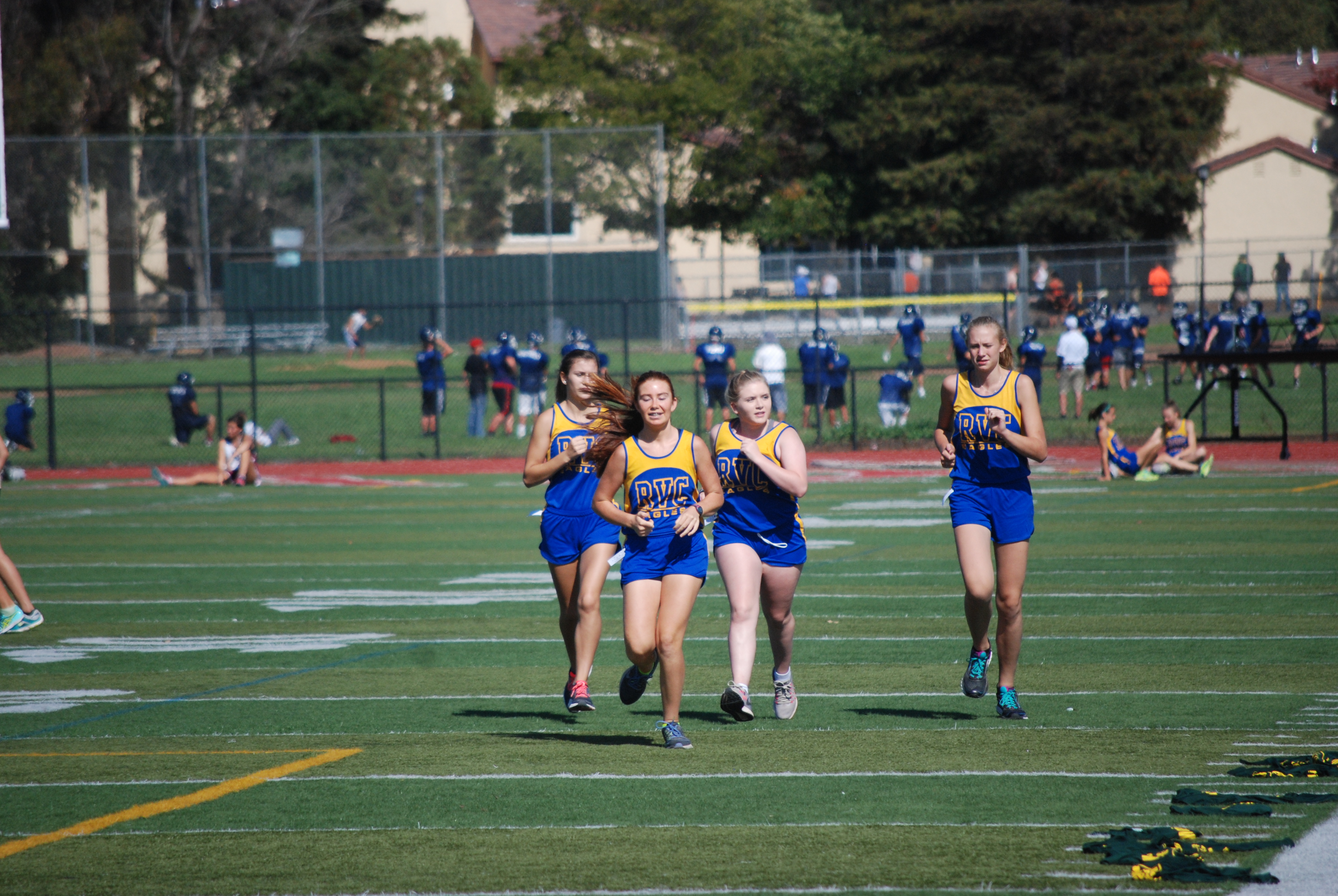 Athlete prepares for pole vault on a track with others watching.