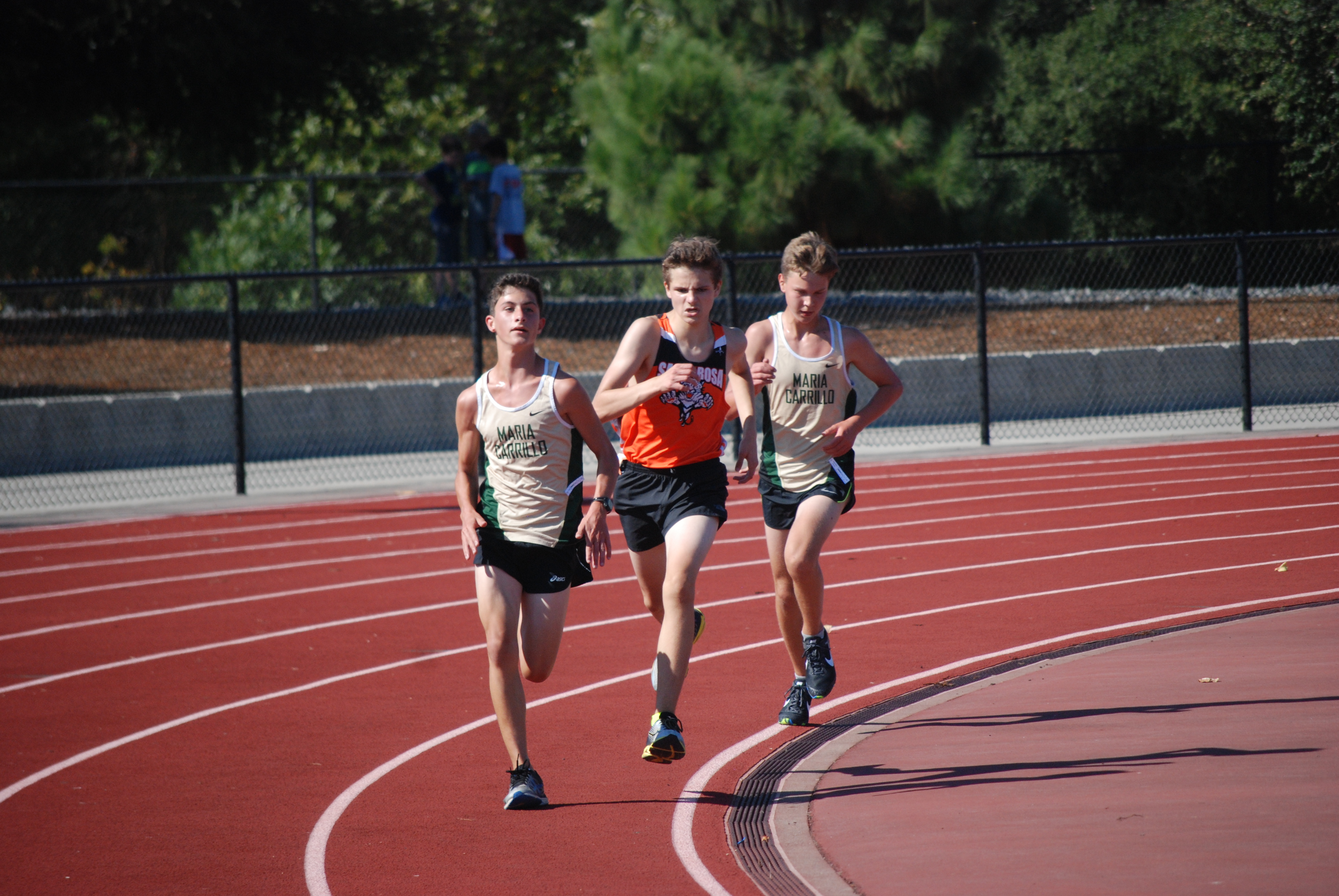 Athlete prepares for pole vault on a track with others watching.