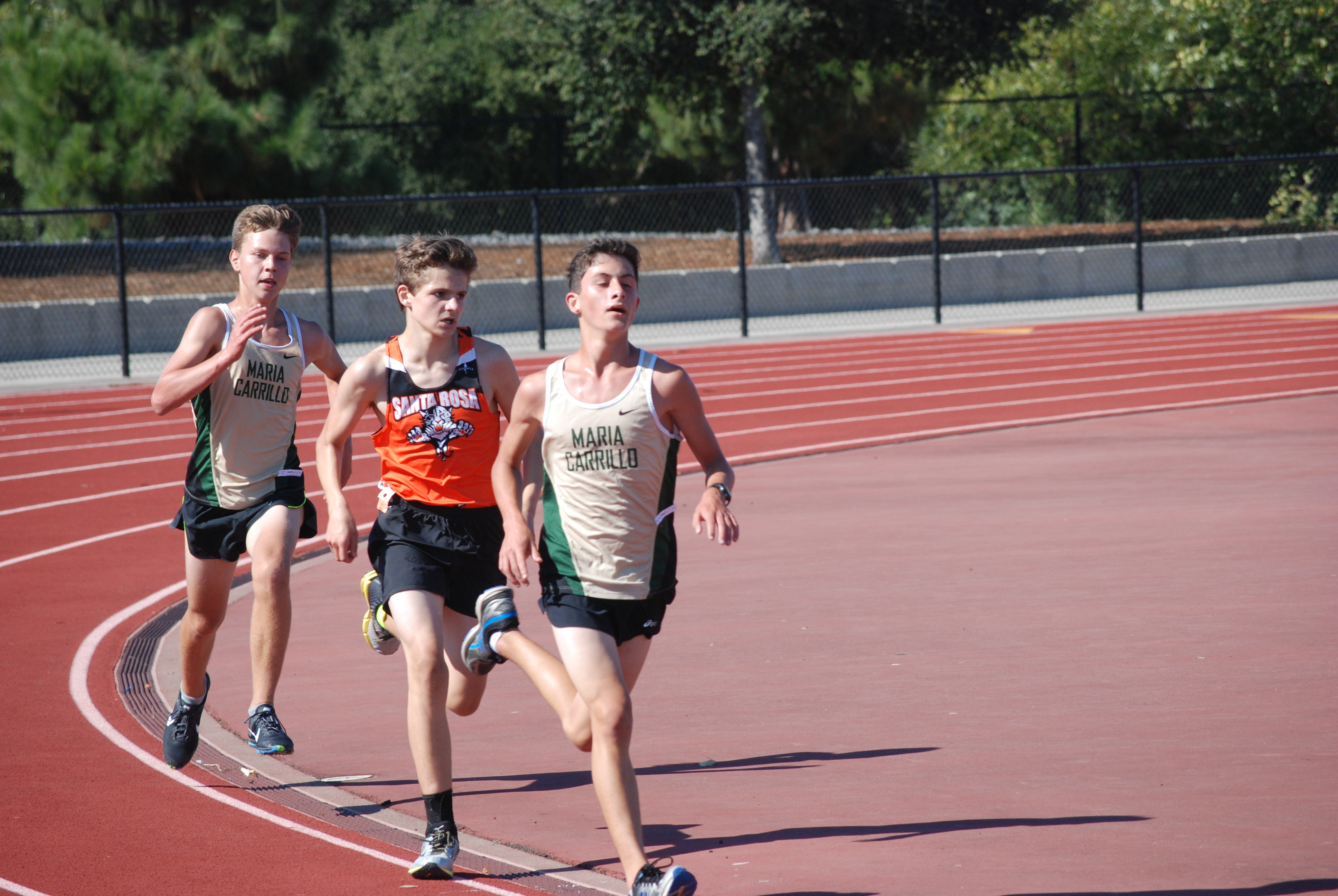 Athlete prepares for pole vault on a track with others watching.