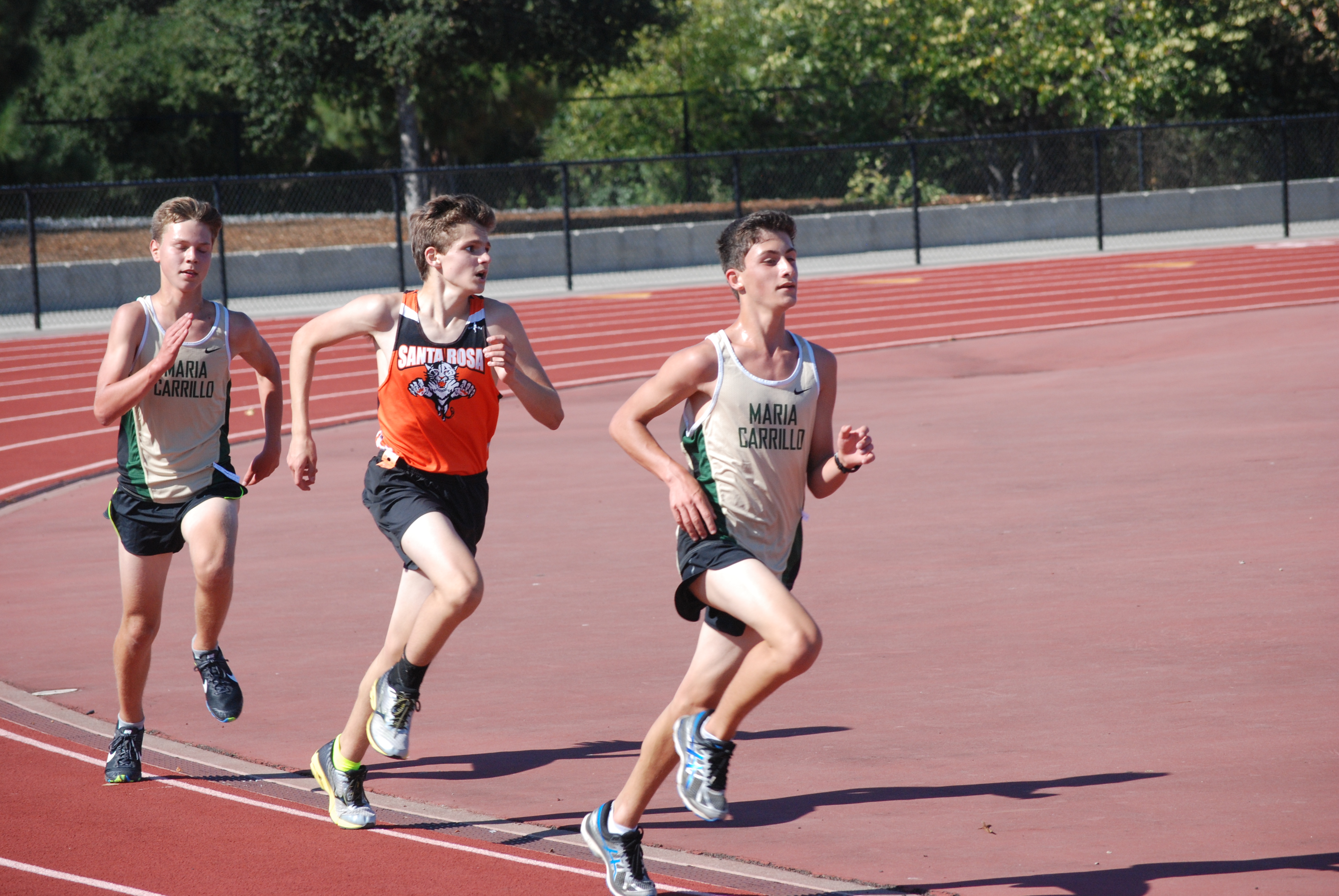 Athlete prepares for pole vault on a track with others watching.