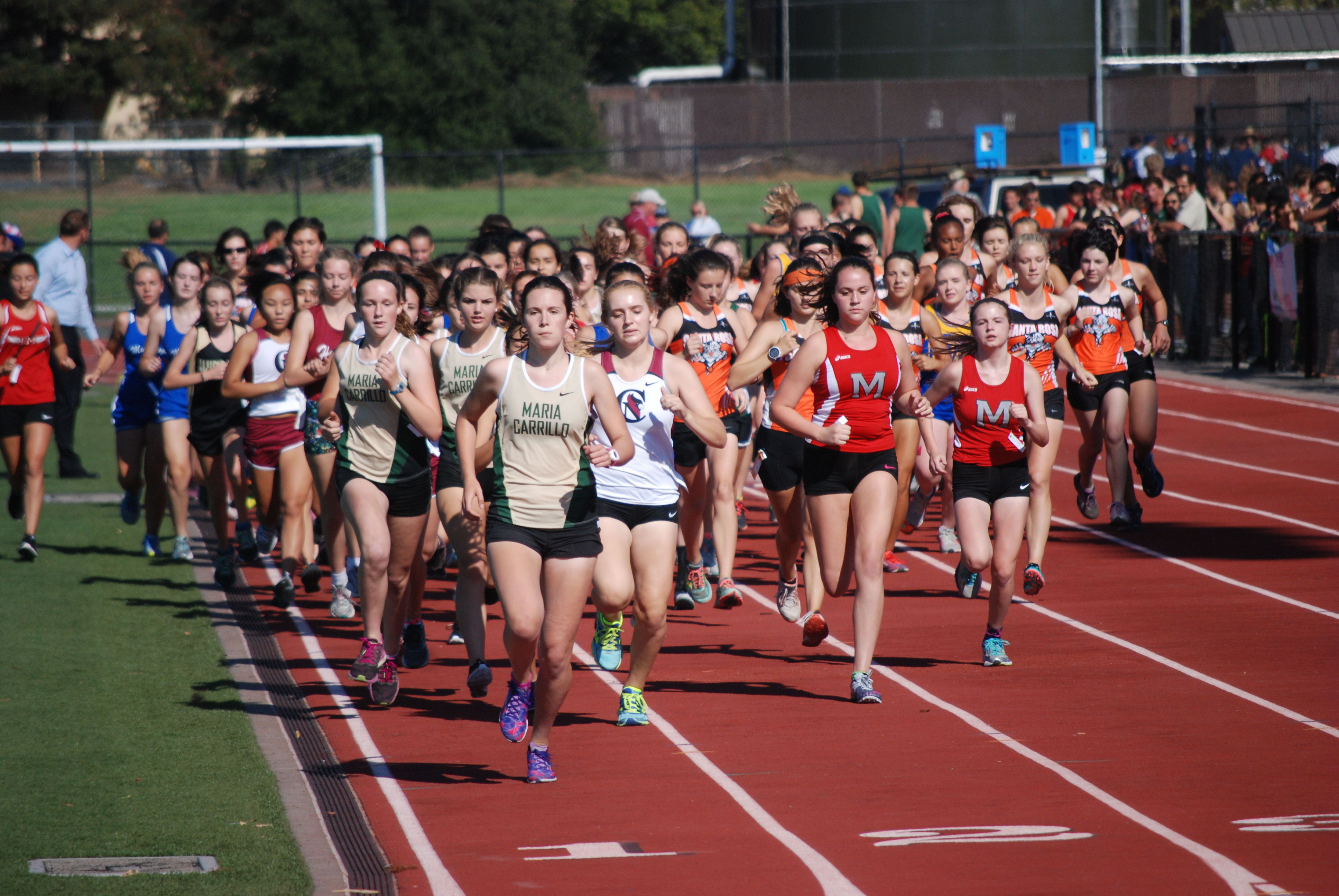 Athlete prepares for pole vault on a track with others watching.