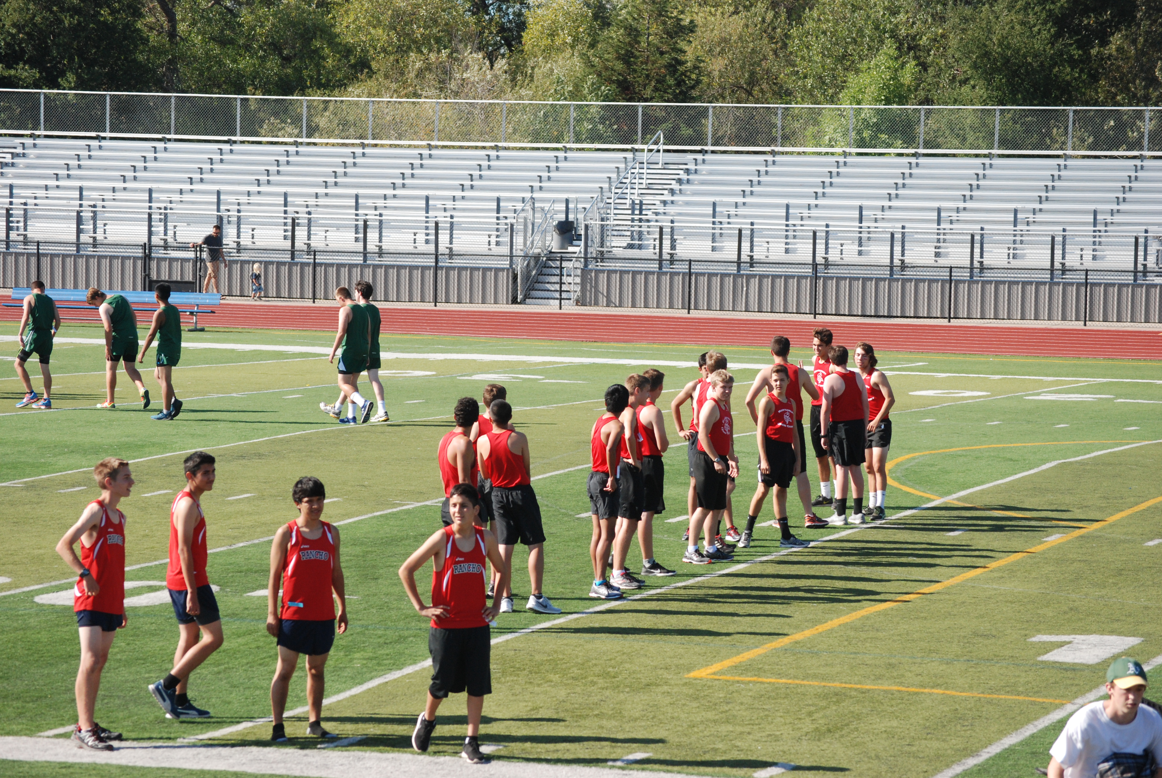 Athlete prepares for pole vault on a track with others watching.