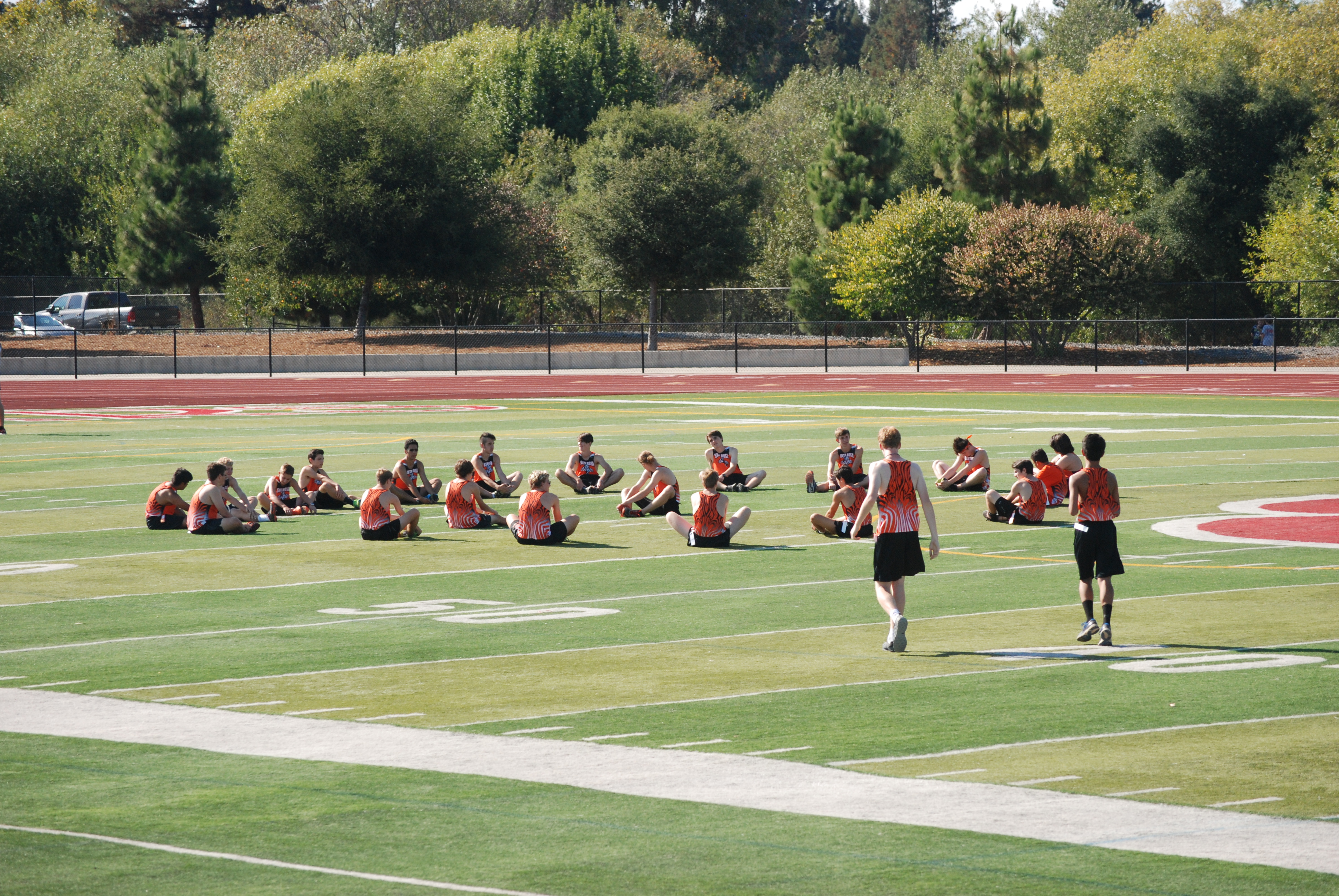 Athlete prepares for pole vault on a track with others watching.