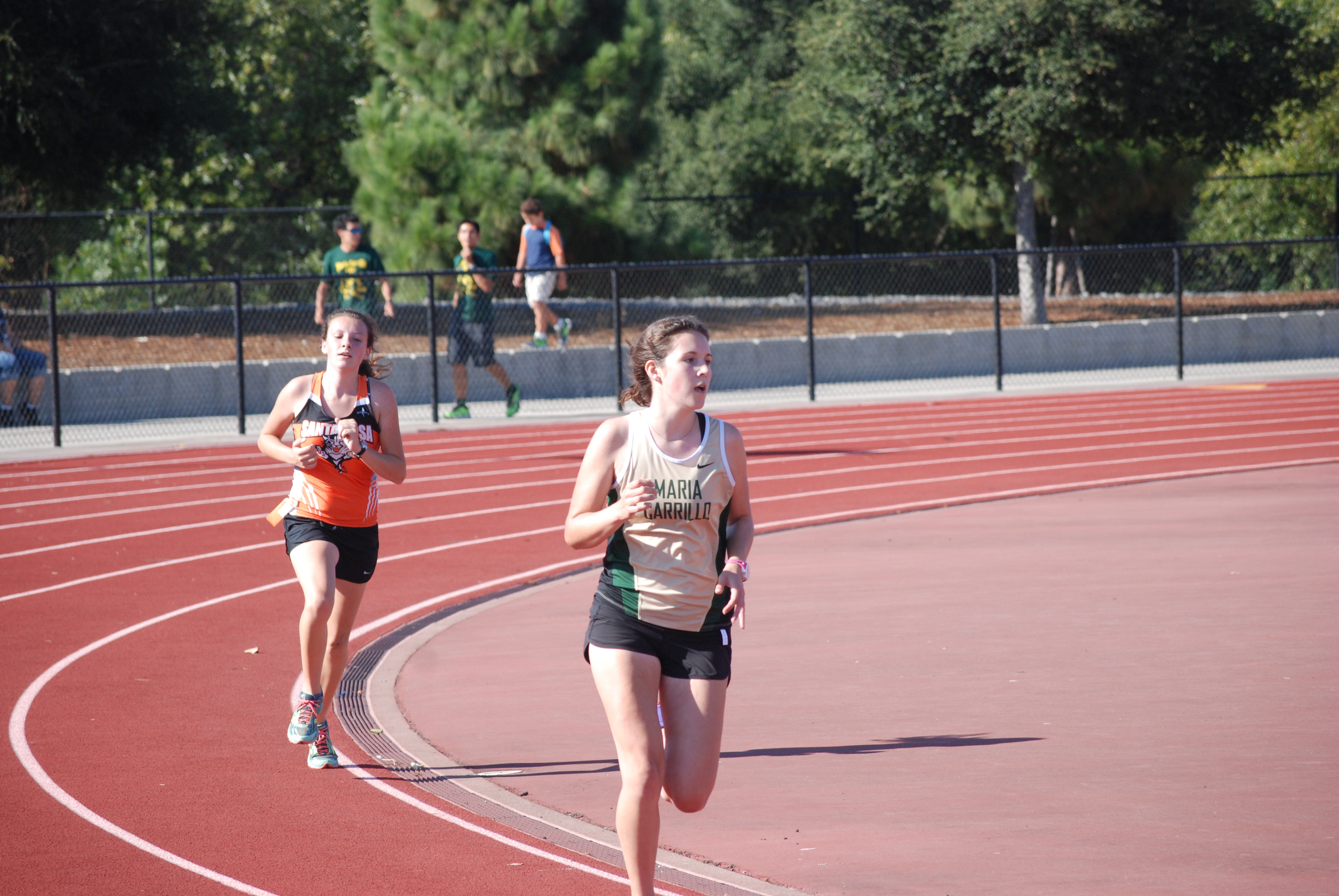 Athlete prepares for pole vault on a track with others watching.