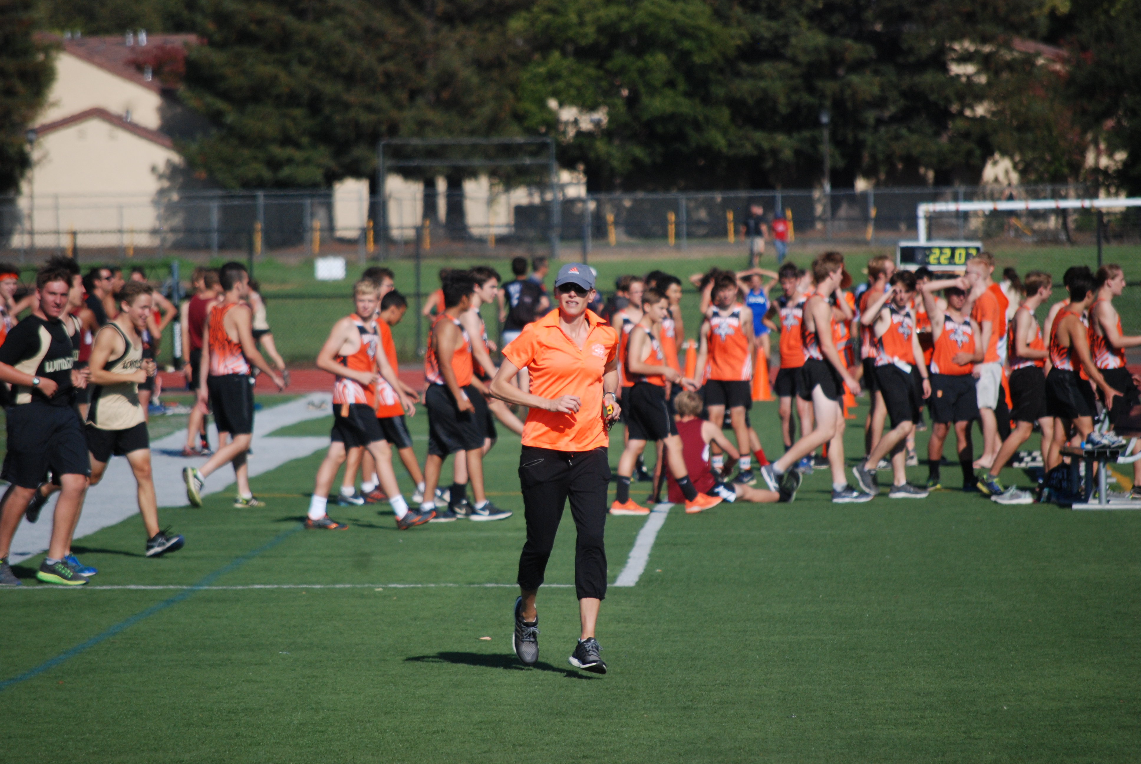 Athlete prepares for pole vault on a track with others watching.