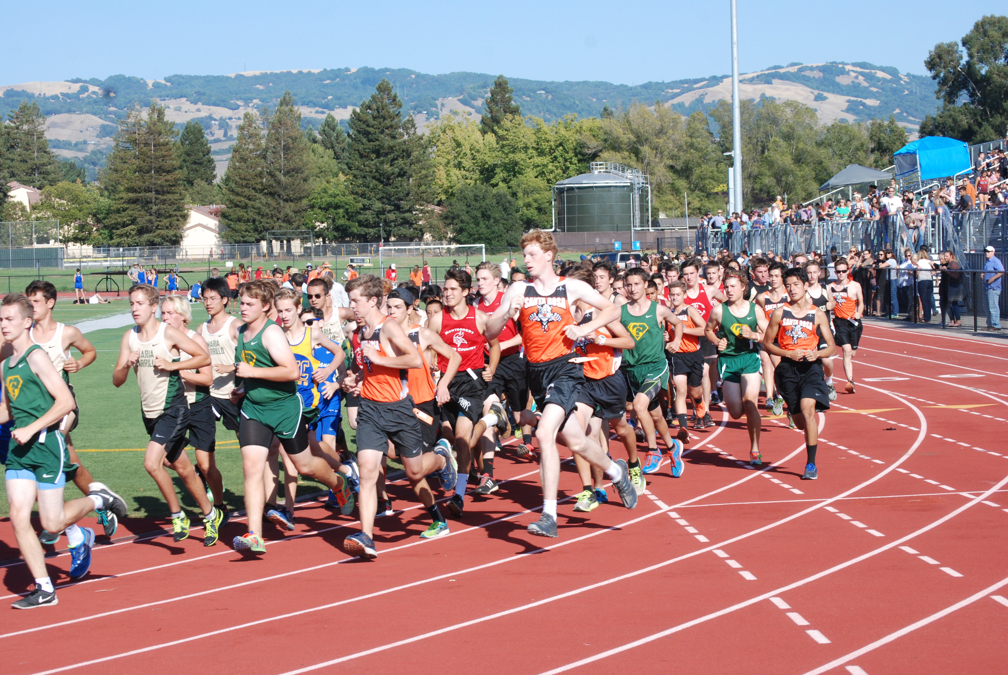 Athlete prepares for pole vault on a track with others watching.