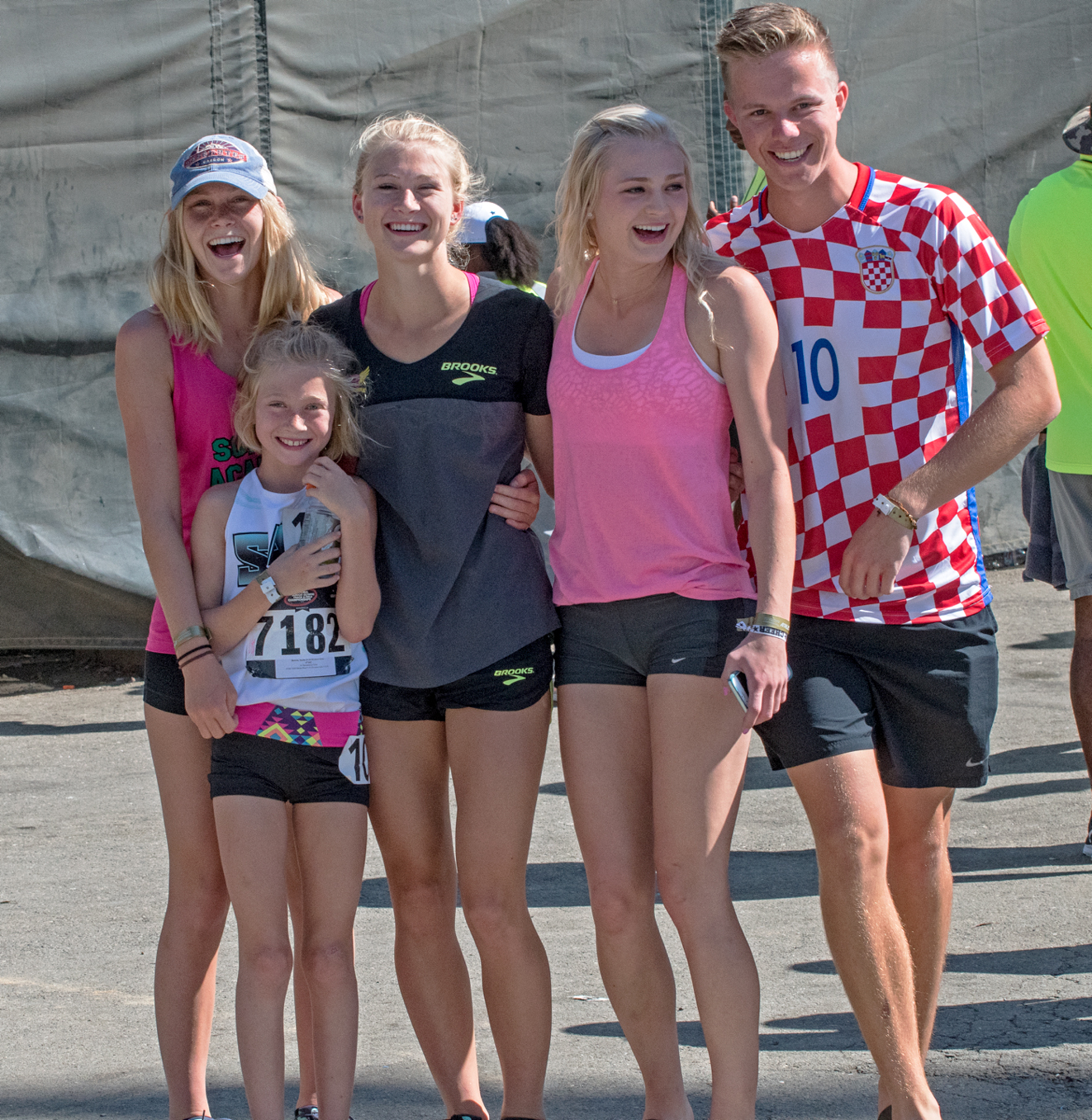 Athlete prepares for pole vault on a track with others watching.