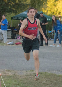 Athlete prepares for pole vault on a track with others watching.