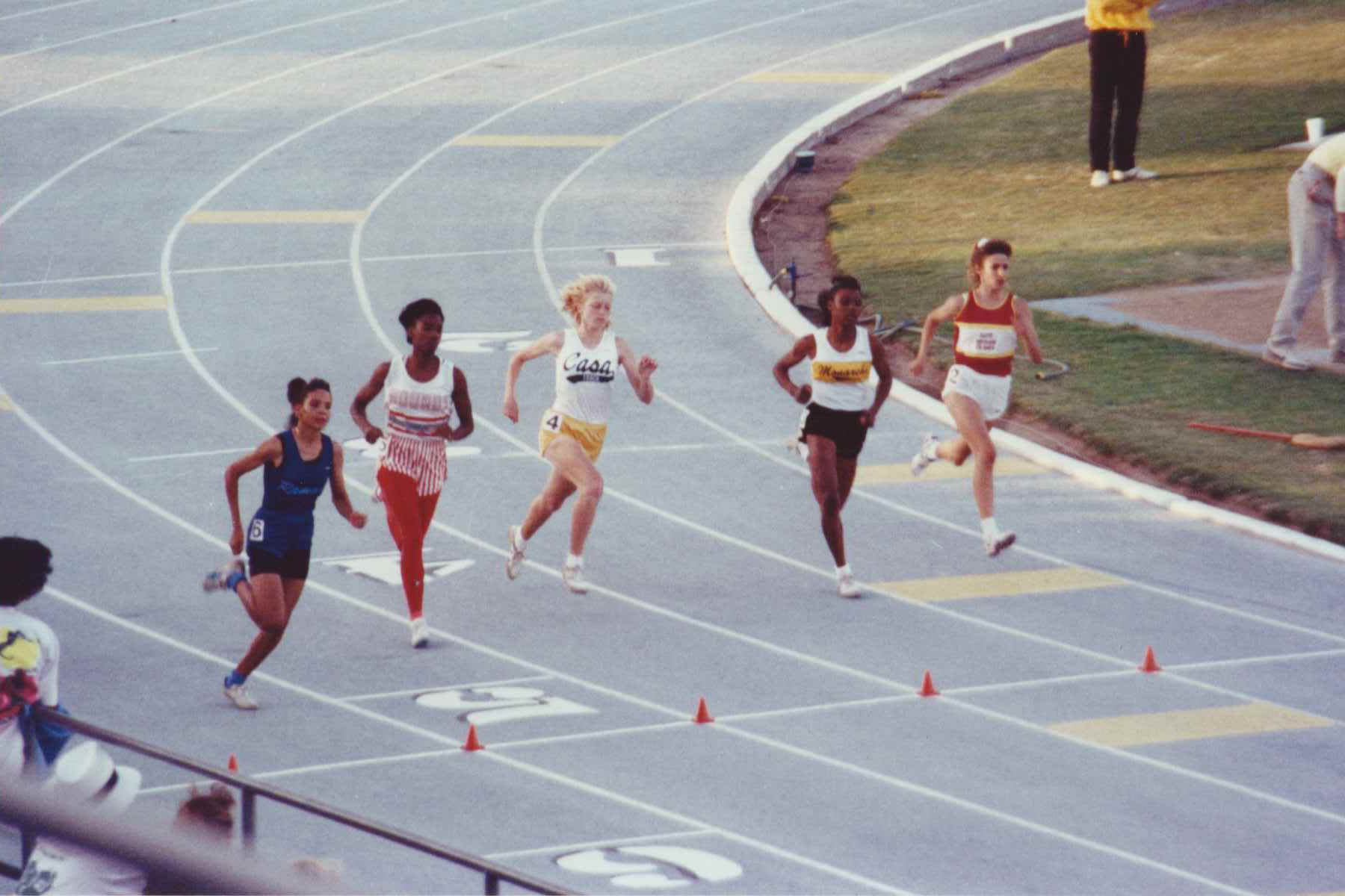 Athlete prepares for pole vault on a track with others watching.