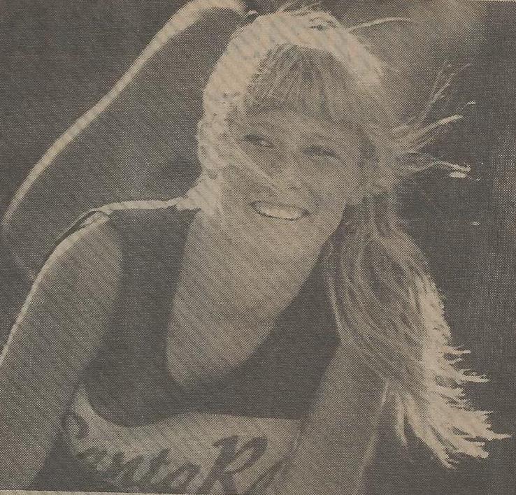 Athlete prepares for pole vault on a track with others watching.