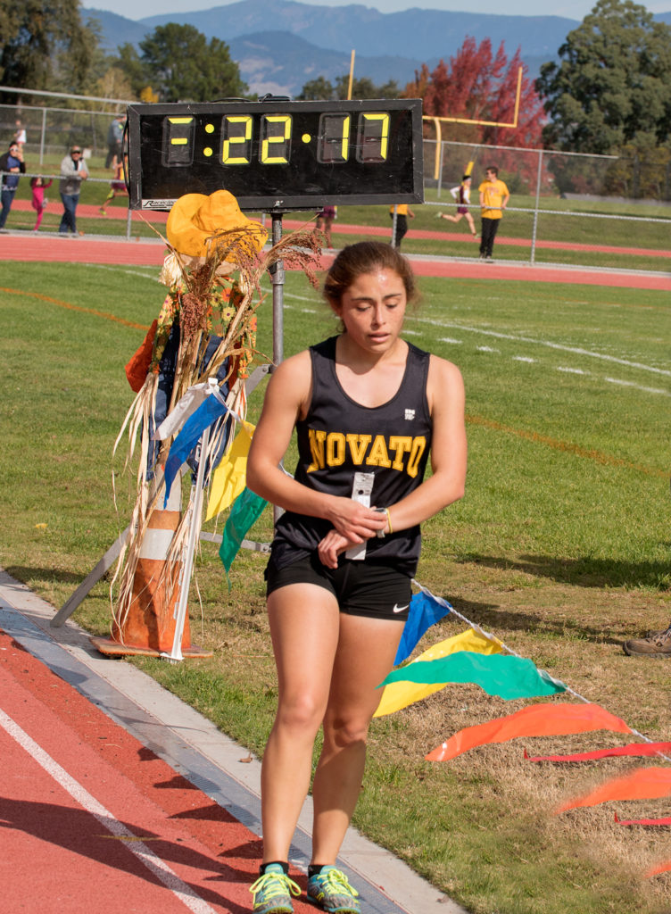 Athlete prepares for pole vault on a track with others watching.