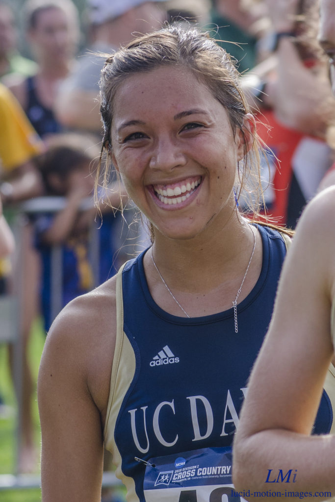 Athlete prepares for pole vault on a track with others watching.