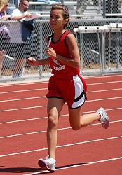 Athlete prepares for pole vault on a track with others watching.